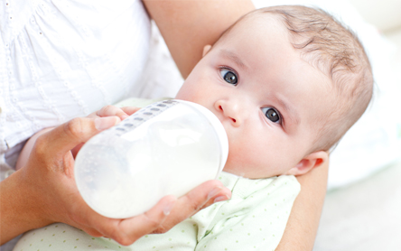 mother bottle feeding baby with formula